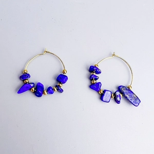 Detail of bohemian hoop earrings with blue natural stones and gold metal beads