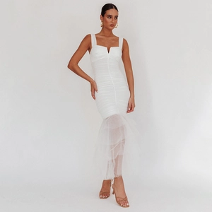 Close-up of white bodycon dress featuring elegant ruched details and a sheer tulle fishtail hem