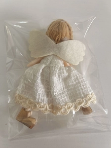Détail de l'ange de Noël avec robe en dentelle et cheveux dorés sous emballage