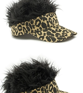 Macro view of leopard print twill fabric and dense black wig hair on a street baseball cap
