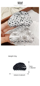 Detail of Halloween spider web and skull hair claw clips with size and weight specs