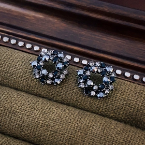Macro detail of dark vintage circular stud earrings with black and clear crystals