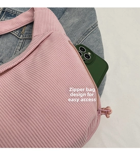 Detailed view of the side zipper pocket on a pink corduroy shoulder bag for smartphones