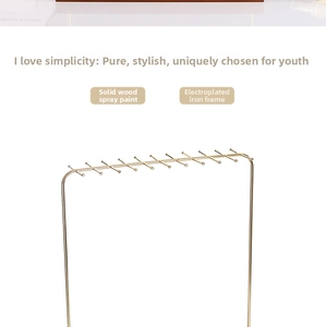 Detail of gold metal necklace holder with wooden base and multiple hanging hooks