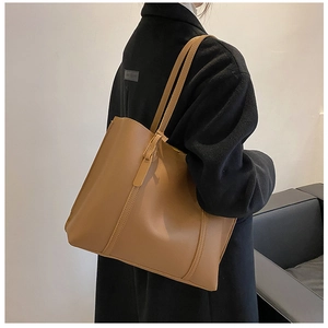Detail of caramel faux leather tote bag showing high-capacity design and strap stitching