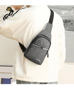 Close-up of a grey men's sling bag with durable fabric and multiple zipper compartments