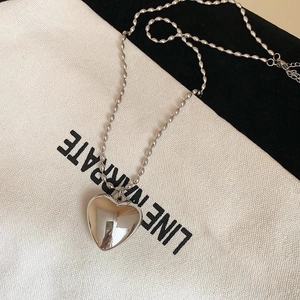 Detailed close-up of a silver heart pendant with mirror finish on a sleek ball chain