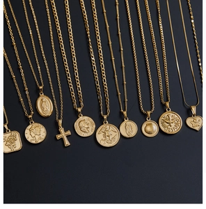 Flat lay of 18K gold plated pendants with coin, cross, shell and heart designs