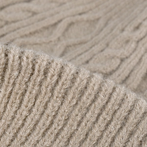 Thick beige cable knit beanie for winter featuring warm ribbed texture and soft wool blend