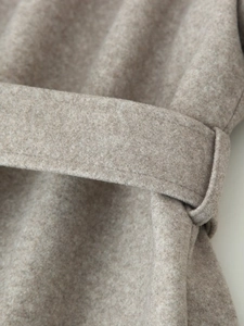 Detailed close-up of the adjustable waist belt and premium wool texture in oatmeal beige