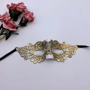 Detailed view of golden lace masquerade mask with intricate embroidery and satin ties