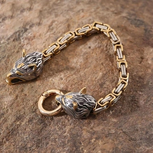 Bracelet tête de loup viking avec chaîne carrée bicolore posé sur une roche brute