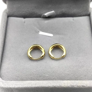 Close-up of golden S925 sterling silver hoop earrings in a grey velvet jewelry box