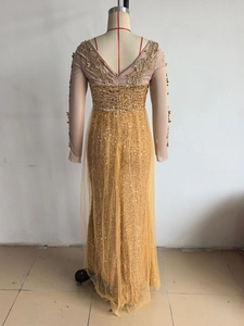 Détail de la robe de soirée dorée à paillettes avec dos en V profond et broderies