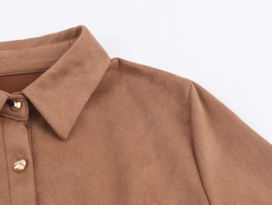 Close-up of brown faux suede dress with textured gold metal buttons and lapel collar