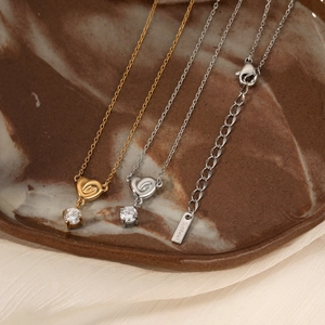 Elegant gold and silver stainless steel heart necklaces with zircon on ceramic tray