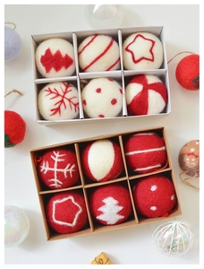Detailed view of handmade red and white felt Christmas balls with festive embroidery