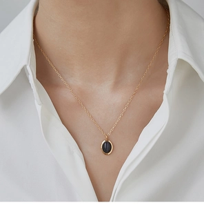 Nahaufnahme einer Vintage-Halskette mit schwarzem Opal-Oval-Anhänger und 18K Goldauflage