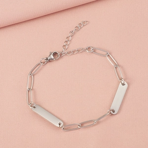 Close-up of polished stainless steel paperclip chain bracelet with engravable tags