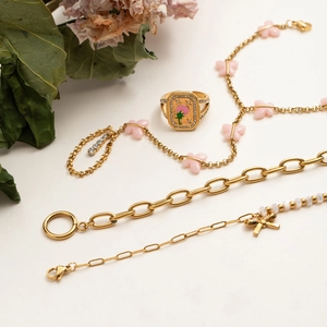 Detail of gold flower bracelets and rings with butterfly motifs and pink palm tree patterns