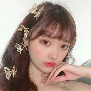 Elegant gold butterfly hair clips with tassels worn by model for a stylish look