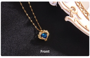 Close-up of golden heart pendant with dark blue crystal and white rhinestones