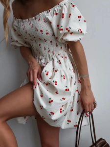 Detail of white square neck mini dress featuring red cherry print and ruched bodice