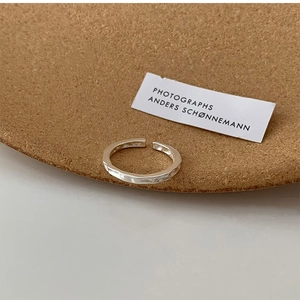 Detail of silver irregular hammered open ring showing light and shadow on metal