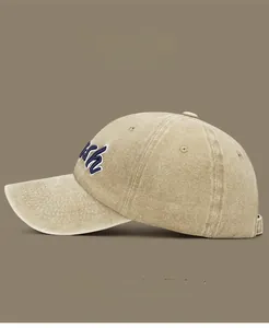 Detail of washed cotton baseball cap with blue KH embroidery in five color options