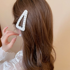 Fermaglio per capelli a triangolo a pois in tessuto indossato da una modella