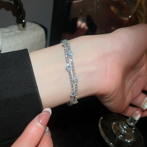Elegant detail view of a luxury double-layer silver zirconia bracelet worn on a wrist.