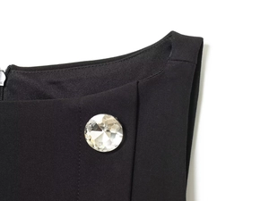 Detail view of black dress shoulder with sparkling crystal button and hidden zipper