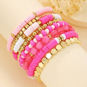 Detail of multi-layer pink and white heishi bead bracelets with gold hex accents