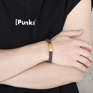 Détail d'un bracelet tressé pour homme avec une plaque métallique étoile dorée
