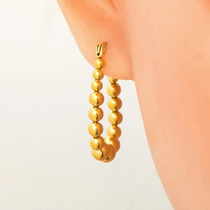 Detailed view of gold plated stainless steel hoop earrings featuring graduated metal spheres