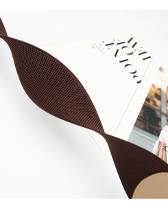 Detail of brown elastic waist belt showing knit texture and beige circular buckle