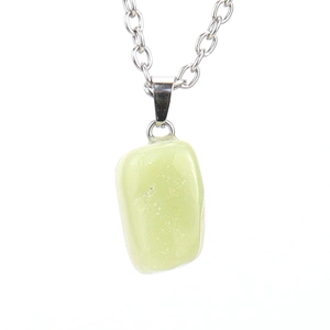 Macro detail of natural light green gemstone pendant on a silver link chain necklace