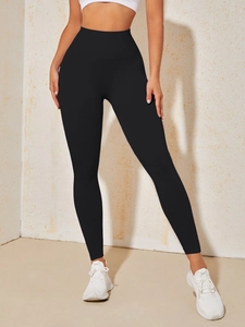 Close-up of seamless black high-waisted yoga leggings with tummy control and lifting effect