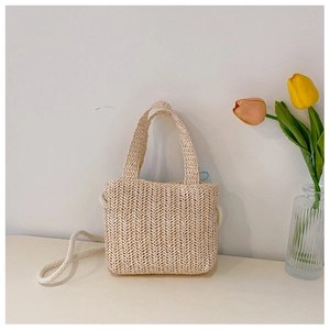 Detailed view of beige straw woven shoulder bag with natural hemp rope strap and tulips
