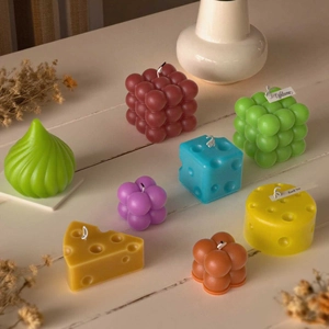 Artistic bubble cube and geometric scented candles with cotton wicks in a cozy home setting