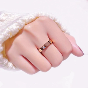Detail of rose gold titanium ring with screw motif and cubic zirconia on model finger