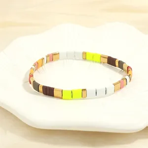 Close-up of a colorful enamel tile stretch bracelet featuring vibrant multi-color metal blocks