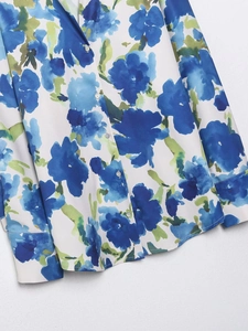 Détail de l'imprimé floral bleu sur chemise en satin soyeux avec boutons blancs