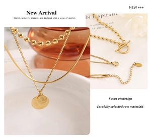 Detailed view of triple-layered gold coin necklaces with OT toggle and lobster clasp