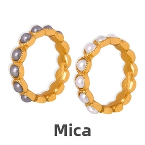 Detail of 18k gold plated wave rings featuring white and grey pearls on white background