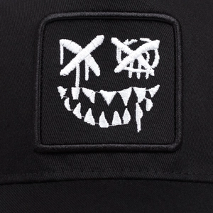 Close-up of black street style cap with detailed white embroidery on cotton twill fabric