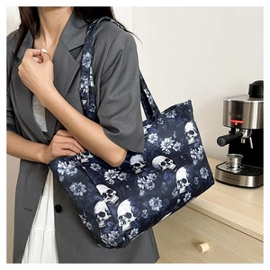Détail d'un sac cabas bleu marine avec imprimé tête de mort et fleurs sur un mannequin