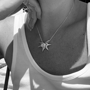 Black and white photo of a woman wearing a titanium steel starfish spiral pendant necklace