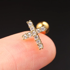 Macro view of gold cross cartilage stud with sparkling cubic zirconia and screw back