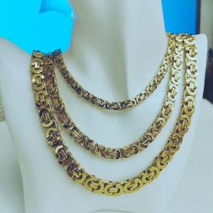 Detailed view of layered gold titanium steel necklaces with intricate Byzantine link style